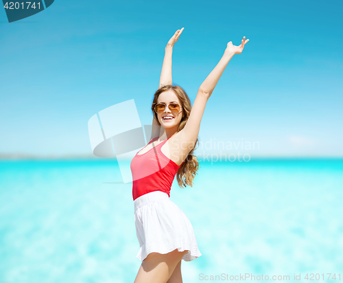 Image of happy young woman in sunglasses on summer beach