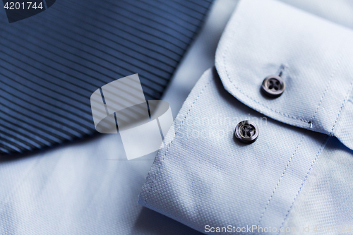 Image of close up of shirt and blue patterned tie