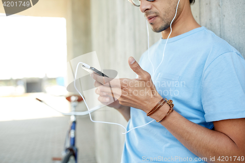 Image of man with earphones and smartphone listening music