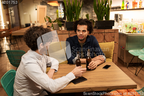 Image of happy male friends drinking beer at bar or pub