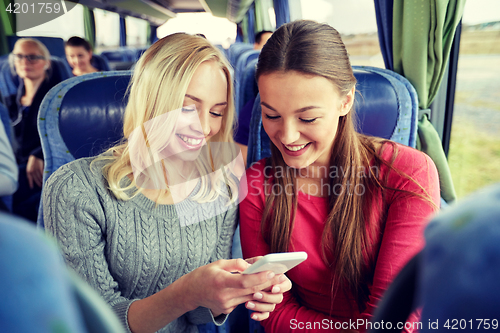 Image of happy young women in travel bus with smartphone