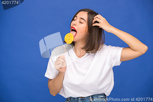 Image of The young woman with colorful lollipop