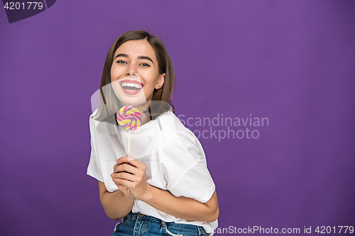 Image of The young woman with colorful lollipop