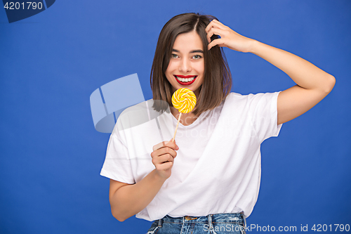 Image of The young woman with colorful lollipop