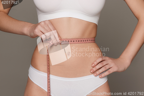 Image of The girl taking measurements of her body, white background.