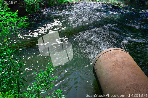 Image of Water flows from the pipe into the river.