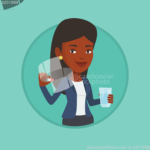 Image of Young african-american woman taking pills.