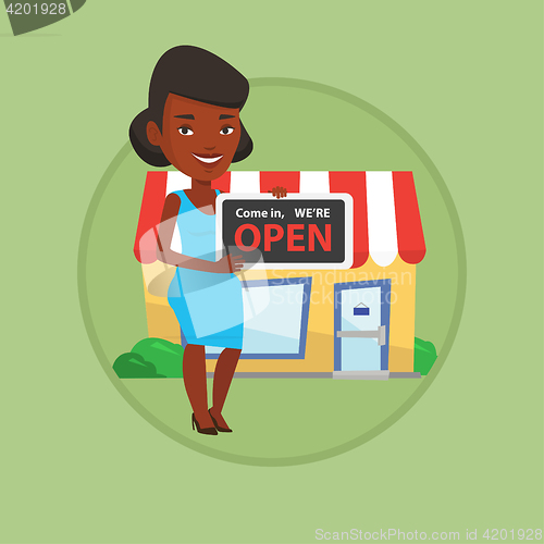 Image of Female shop owner holding open signboard.