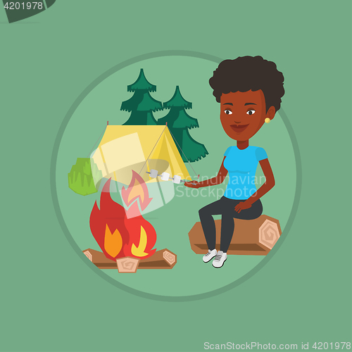 Image of Woman roasting marshmallow over campfire.