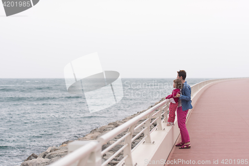 Image of mother and cute little girl on the promenade by the sea