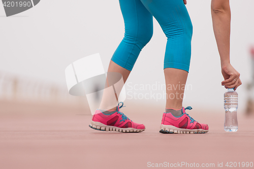 Image of close up on running shoes and bottle of water