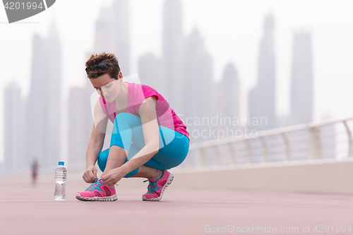 Image of woman tying shoelaces on sneakers