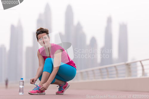 Image of woman tying shoelaces on sneakers