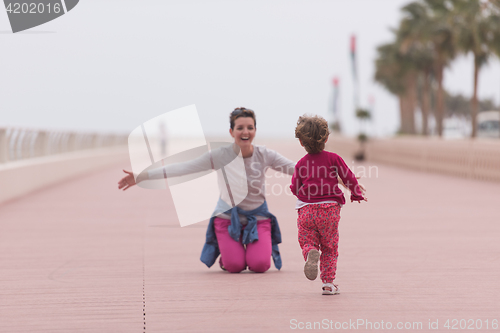 Image of mother and cute little girl on the promenade by the sea