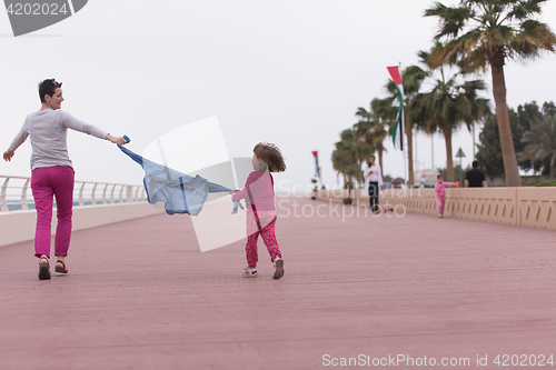 Image of mother and cute little girl on the promenade by the sea