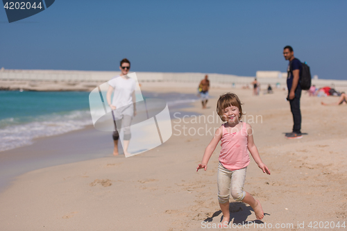 Image of mother and daughter running on the beach