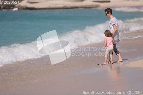 Image of mother and daughter running on the beach