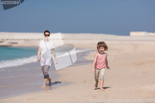 Image of mother and daughter running on the beach