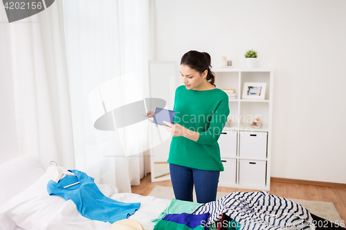 Image of woman with passport packing travel bag at home