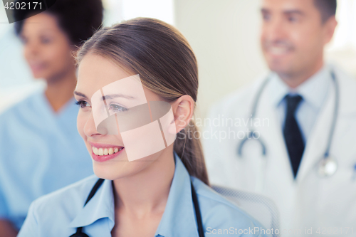 Image of happy doctor over group of medics at hospital