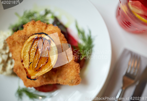 Image of close up of fish salad with roasted lemon on plate