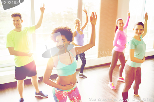 Image of group of smiling people dancing in gym or studio