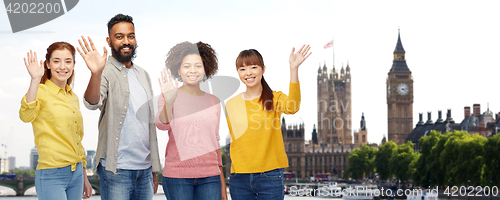 Image of international group of happy people waving hands