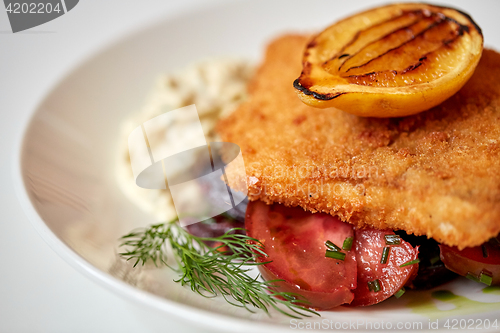 Image of close up of fish salad with roasted lemon on plate