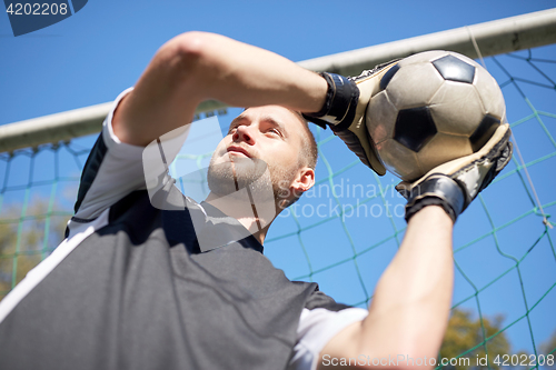 Image of goalkeeper with ball at football goal on field