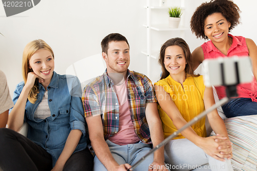 Image of happy friends taking selfie by smartphone at home