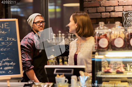 Image of happy bartenders at cafe or coffee shop counter