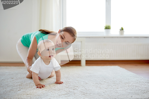 Image of happy mother playing with baby at home