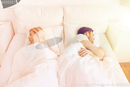 Image of couple sleeping in bed at home