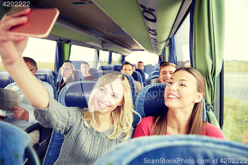 Image of women taking selfie by smartphone in travel bus