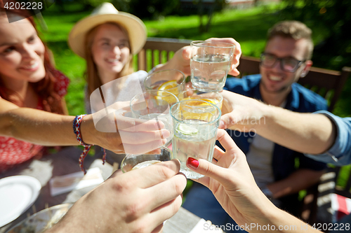 Image of happy friends with drinks at summer garden party