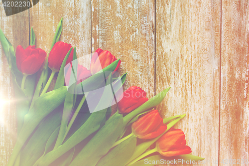 Image of close up of red tulips on wooden background