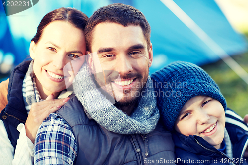 Image of happy family with tent at camp site