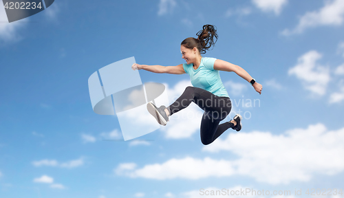 Image of happy smiling sporty young woman jumping in sky