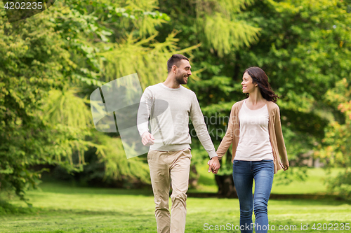 Image of happy couple walking in summer park