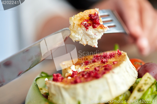 Image of close up of woman eating goat cheese salad