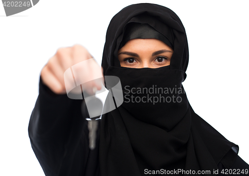 Image of muslim woman in hijab with car key over white