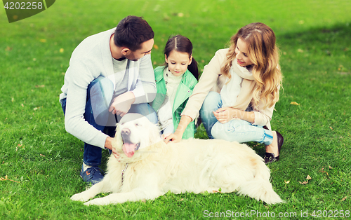 Image of happy family with labrador retriever dog in park