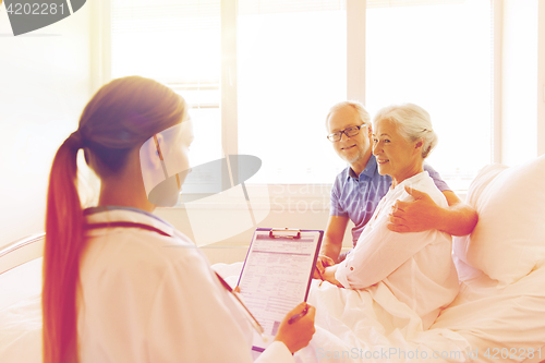 Image of senior woman and doctor with clipboard at hospital