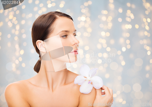 Image of beautiful young woman with orchid flower