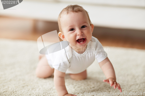 Image of little baby in diaper crawling on floor at home