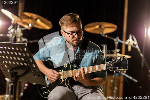 Image of man playing guitar at studio rehearsal