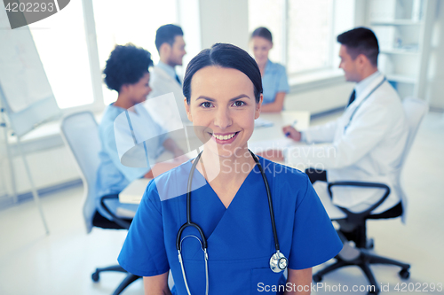 Image of happy doctor over group of medics at hospital