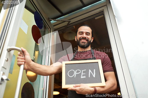 Image of man or waiter with blackboard at bar entrance door