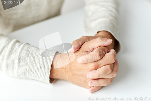Image of close up of senior man hands on table
