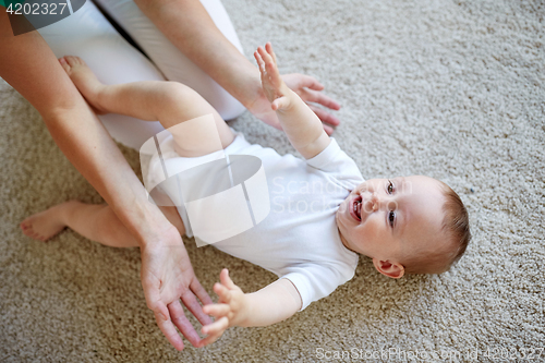 Image of happy mother playing with baby at home